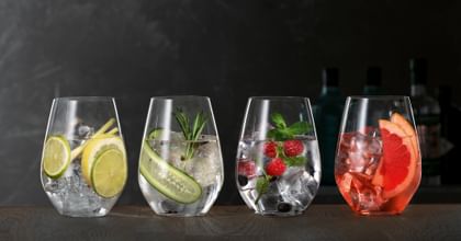Copas de Gin Tonic SPIEGELAU sobre un aparador de madera, cada una de ellas llena de un Gin Cocktail diferente.<br/>