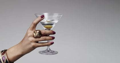 A lady's hand holding the Spiegelau Perfect Serve Cocktail glass filled with a Martini.