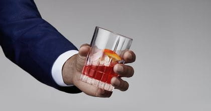 Man holding a Spiegelau Perfect Serve Collection Small Long Drink glass filled with an Americano cocktail.